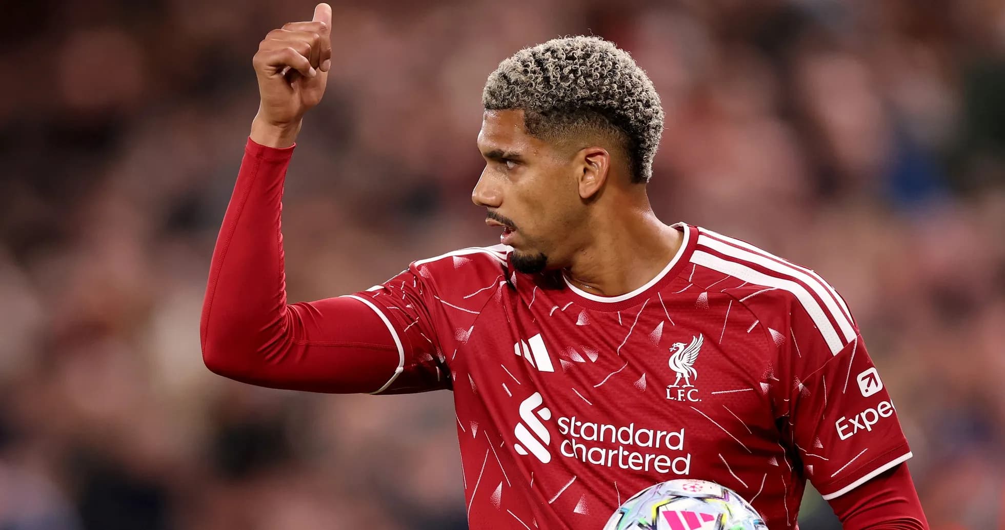 Futbolchi Liverpool formasida ko'tarilgan qo'l bilan Futbolchi Liverpool formasida ko'tarilgan qo'l bilan