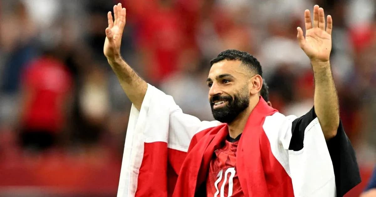 Futbolchi qo'lini ko'tarib muxlislarga salom berayapti Futbolchi qo'lini ko'tarib muxlislarga salom berayapti