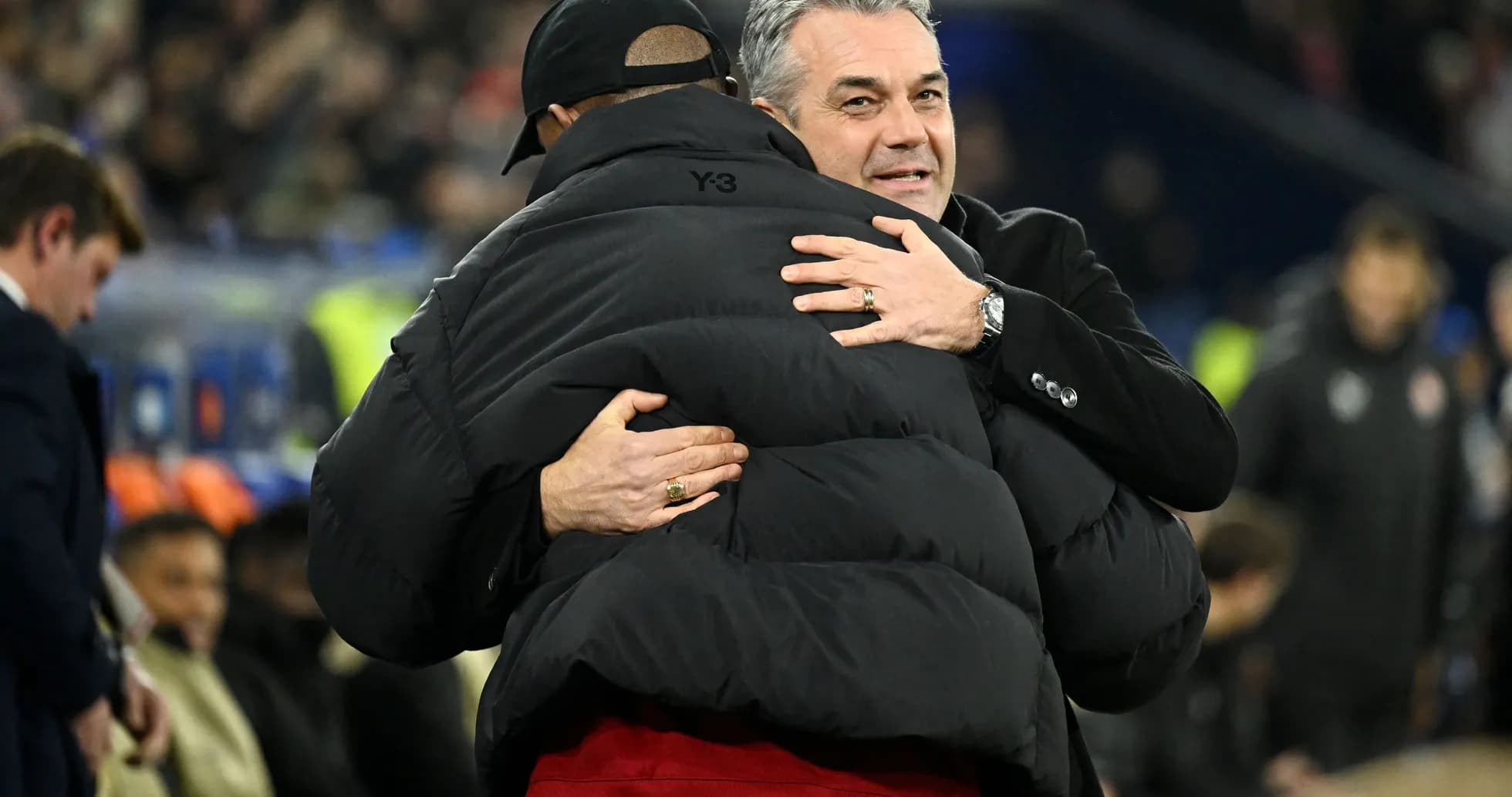 Trainers embracing on the sidelines during match Trainers embracing on the sidelines during match