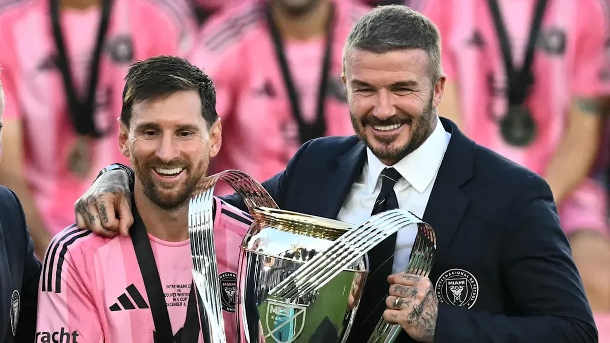 Lionel Messi and David Beckham holding trophy together Lionel Messi and David Beckham holding trophy together