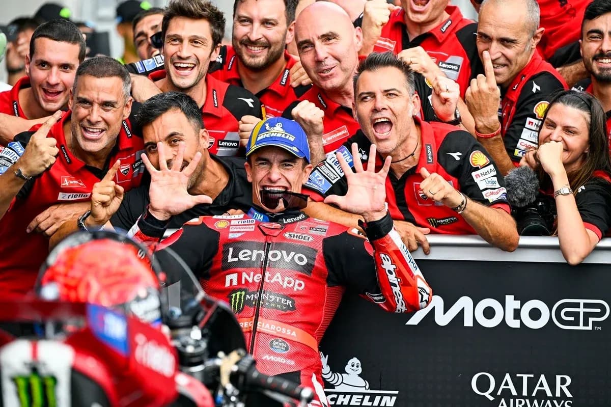 Ducati team celebrating victory with rider in garage Ducati team celebrating victory with rider in garage