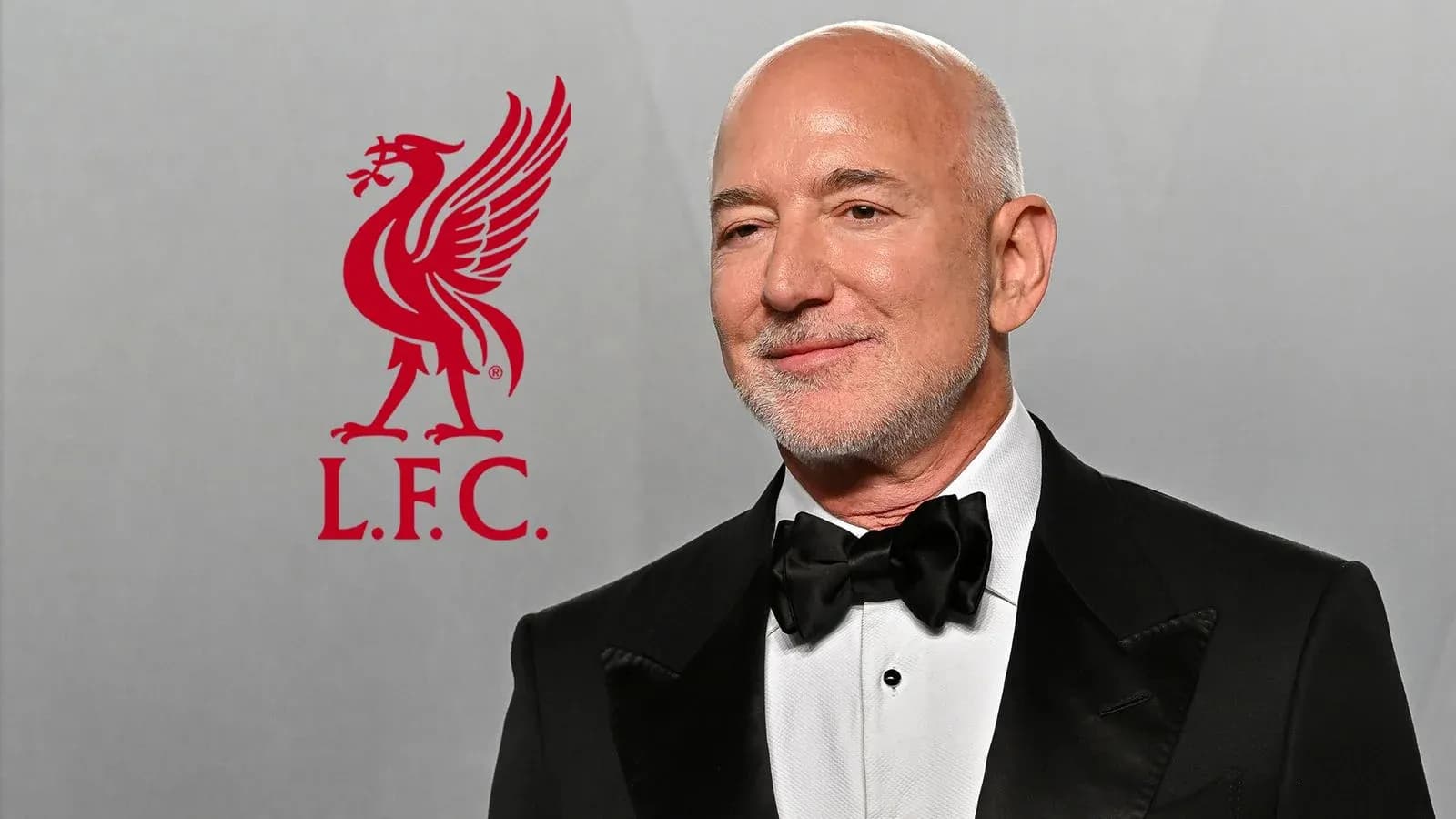 Man in tuxedo with Liverpool FC logo backdrop Man in tuxedo with Liverpool FC logo backdrop