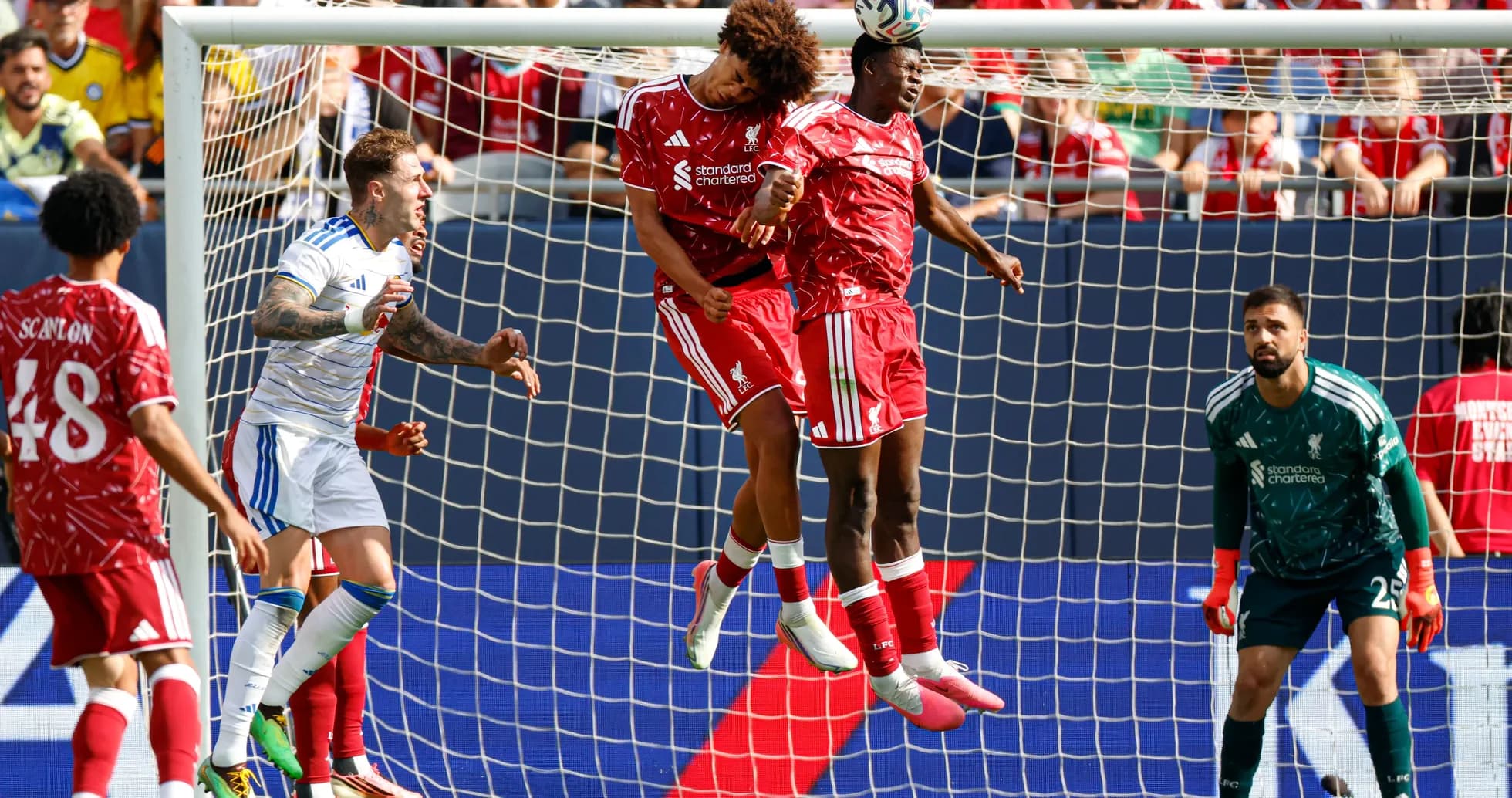 Liverpool players jumping to head the ball in match Liverpool players jumping to head the ball in match