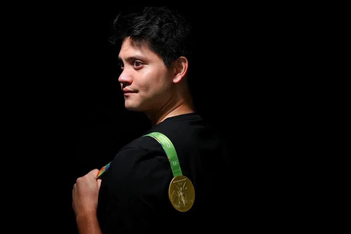 Athlete holding Olympic gold medal on shoulder Athlete holding Olympic gold medal on shoulder