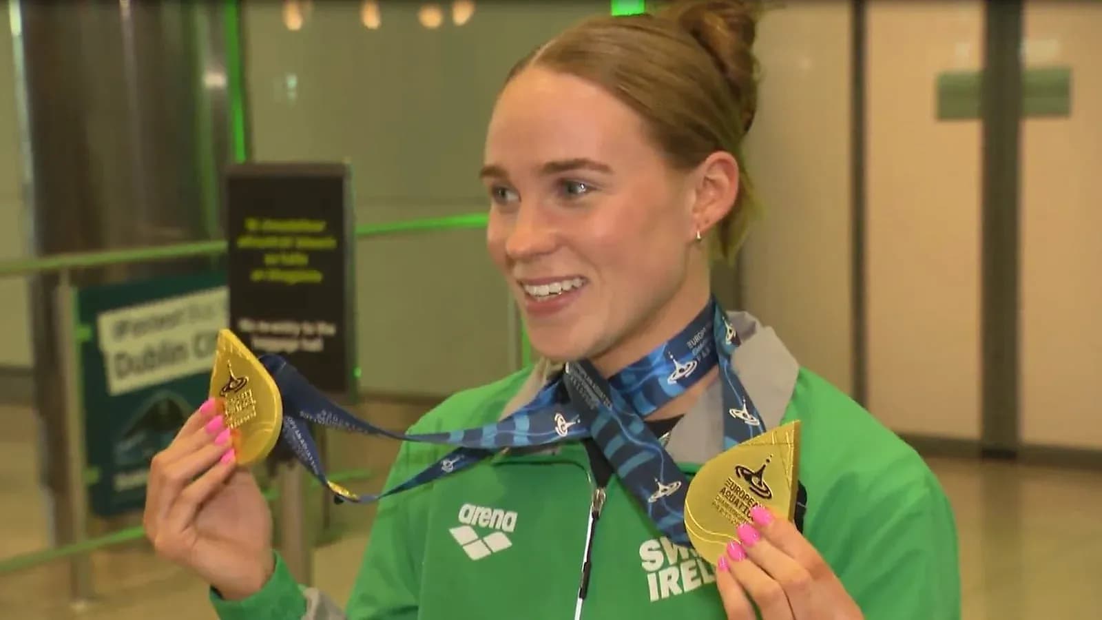 Athlete holding gold medals at airport arrival Athlete holding gold medals at airport arrival