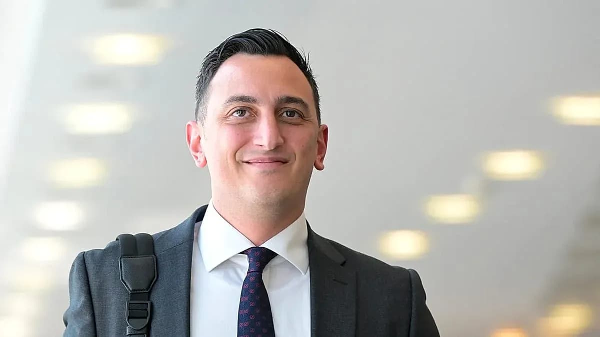 Man in suit smiling with briefcase in hallway Man in suit smiling with briefcase in hallway