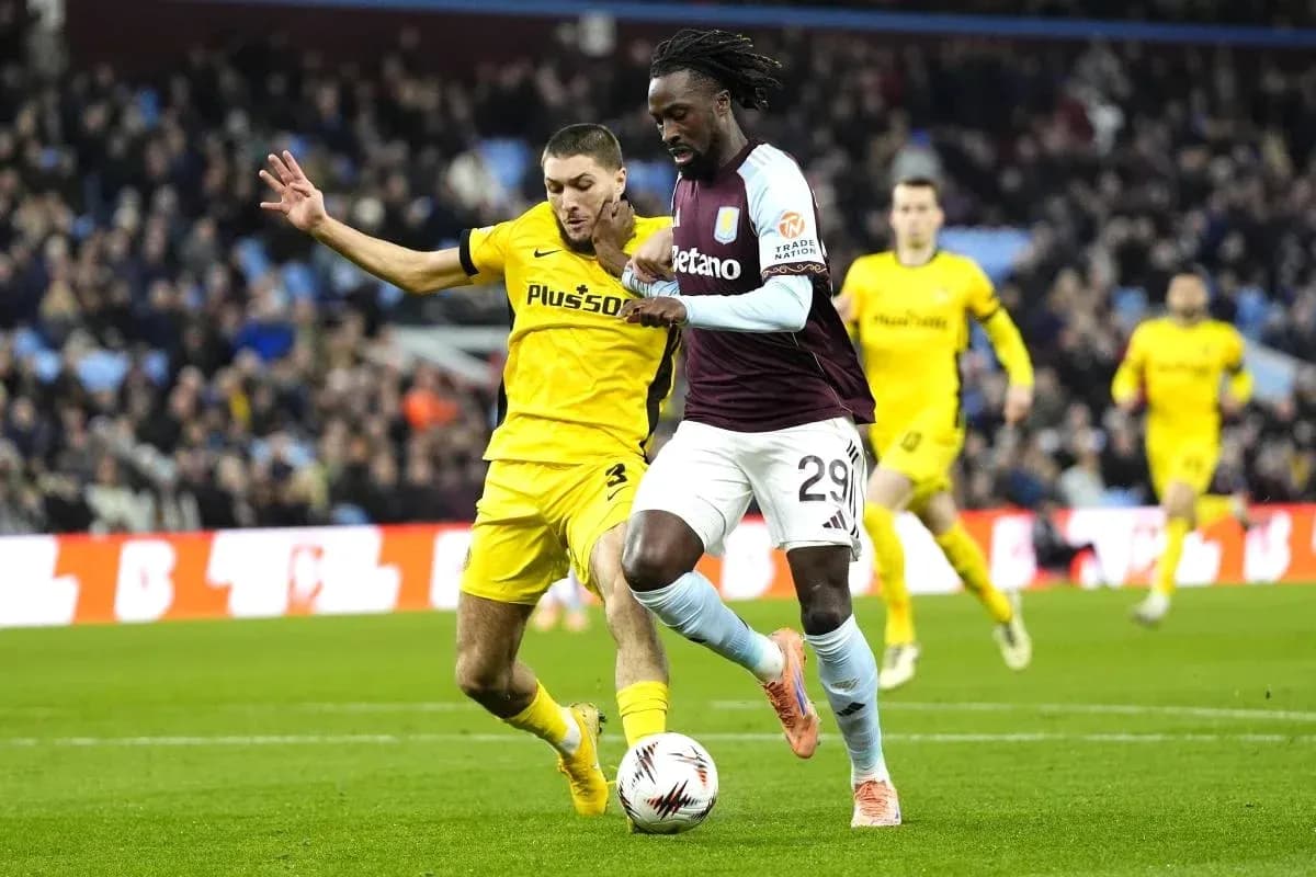 Aston Villa player dribbling past opponent during match Aston Villa player dribbling past opponent during match