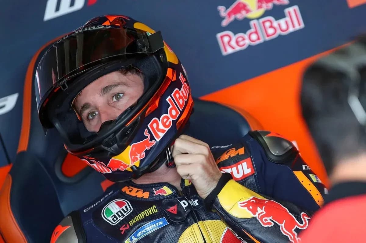 Motosport rider adjusting helmet before race Motosport rider adjusting helmet before race