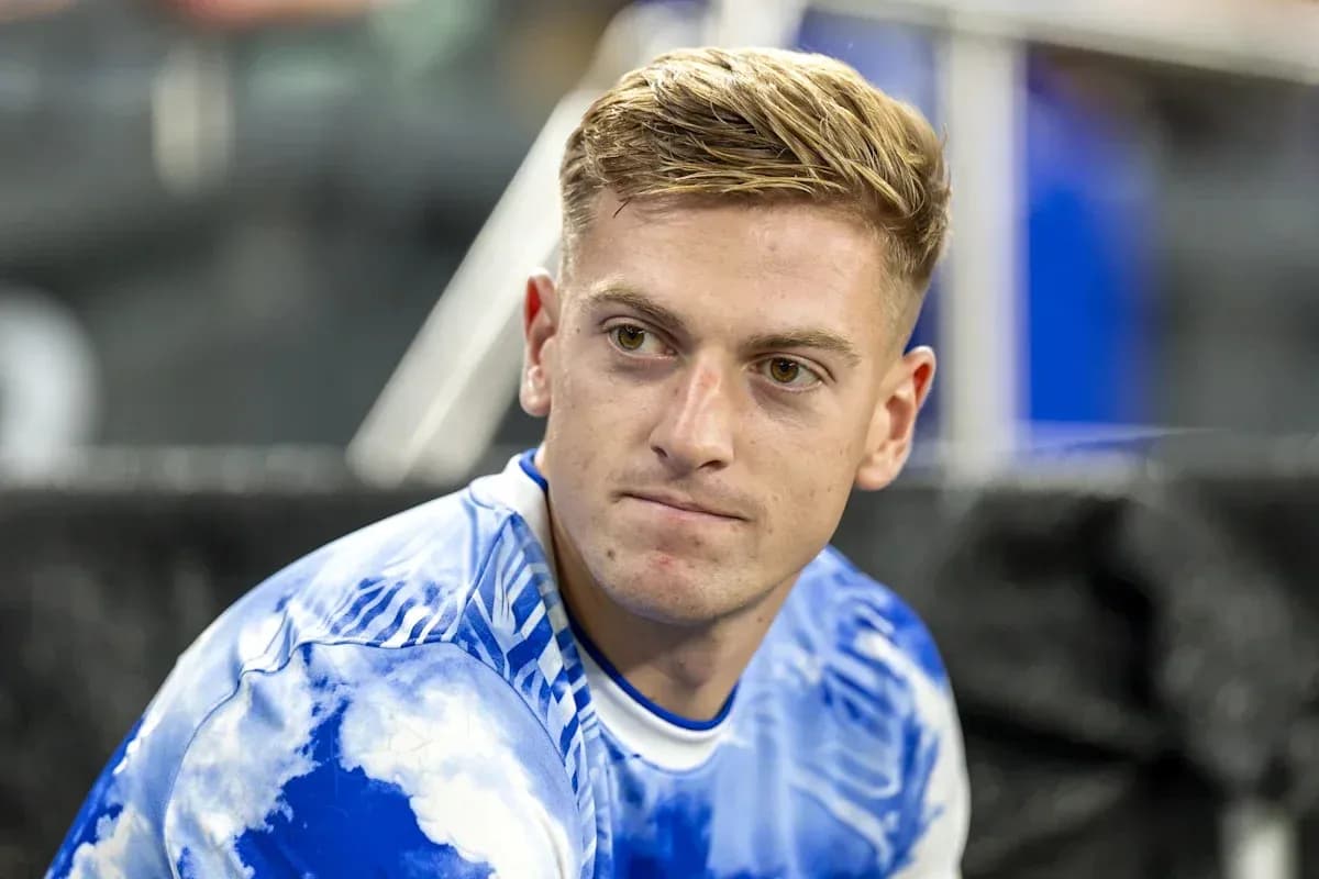 Futbolchi benchda o'tirgan holda tasvirlangan Futbolchi benchda o'tirgan holda tasvirlangan