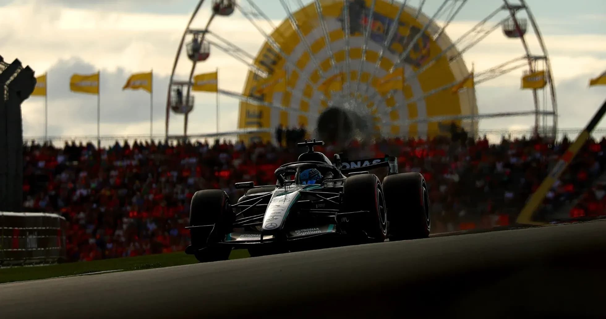 Formula 1 car racing with ferris wheel background Formula 1 car racing with ferris wheel background