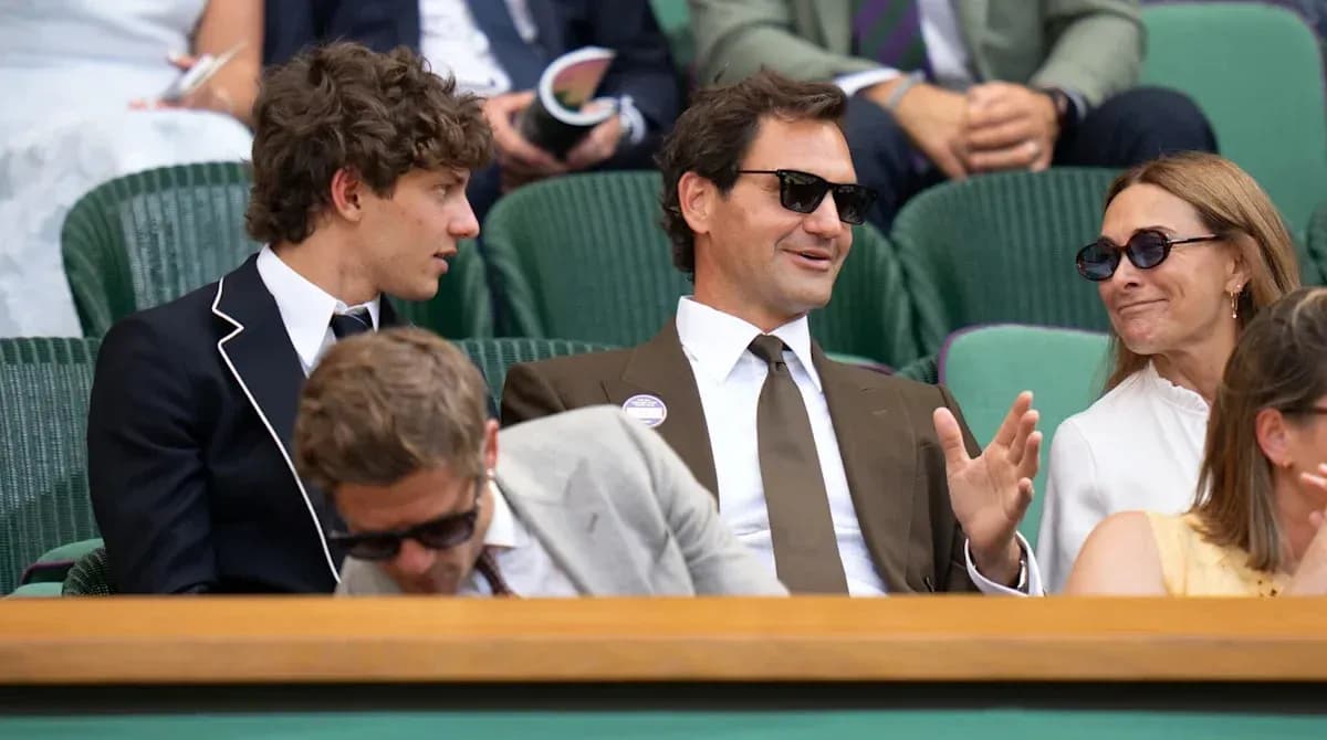 Four people seated in a box at Wimbledon Four people seated in a box at Wimbledon