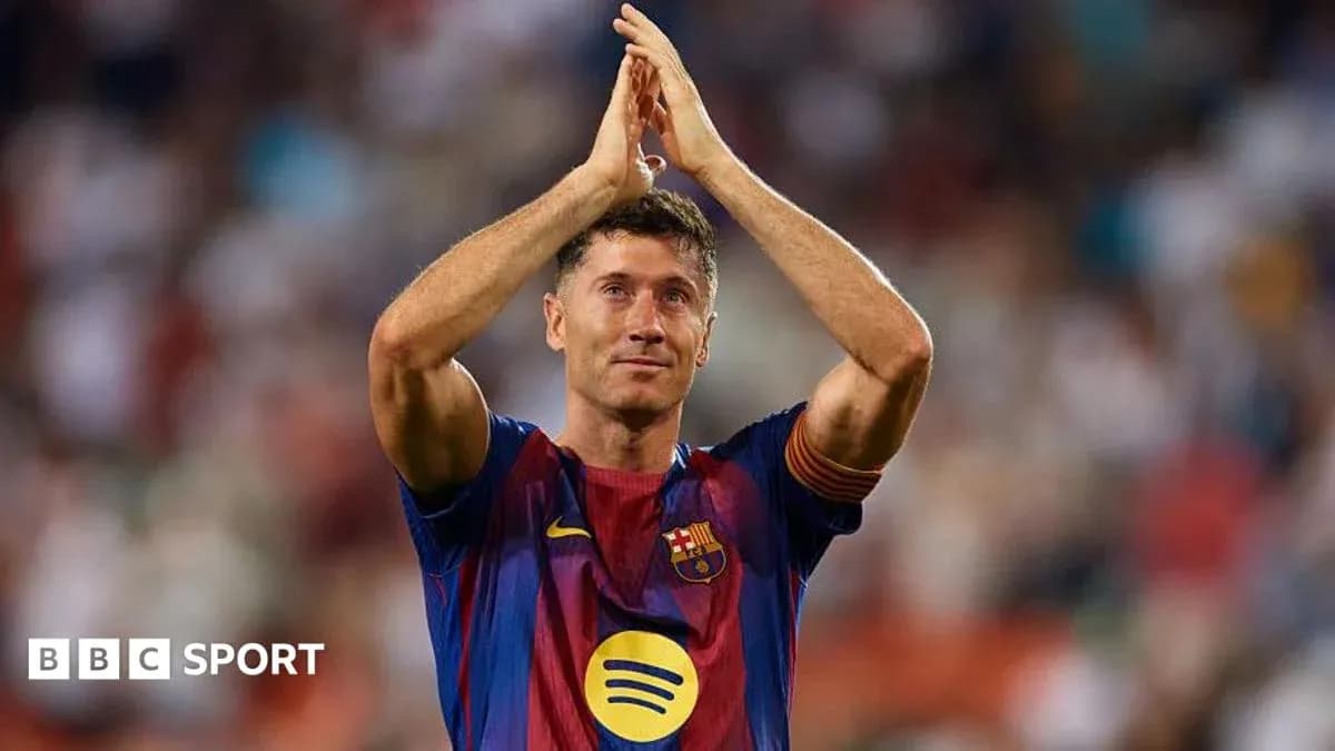 Futbolchi Robert Lewandowski stadion oldida qo'lini ko'tarib turibdi Futbolchi Robert Lewandowski stadion oldida qo'lini ko'tarib turibdi