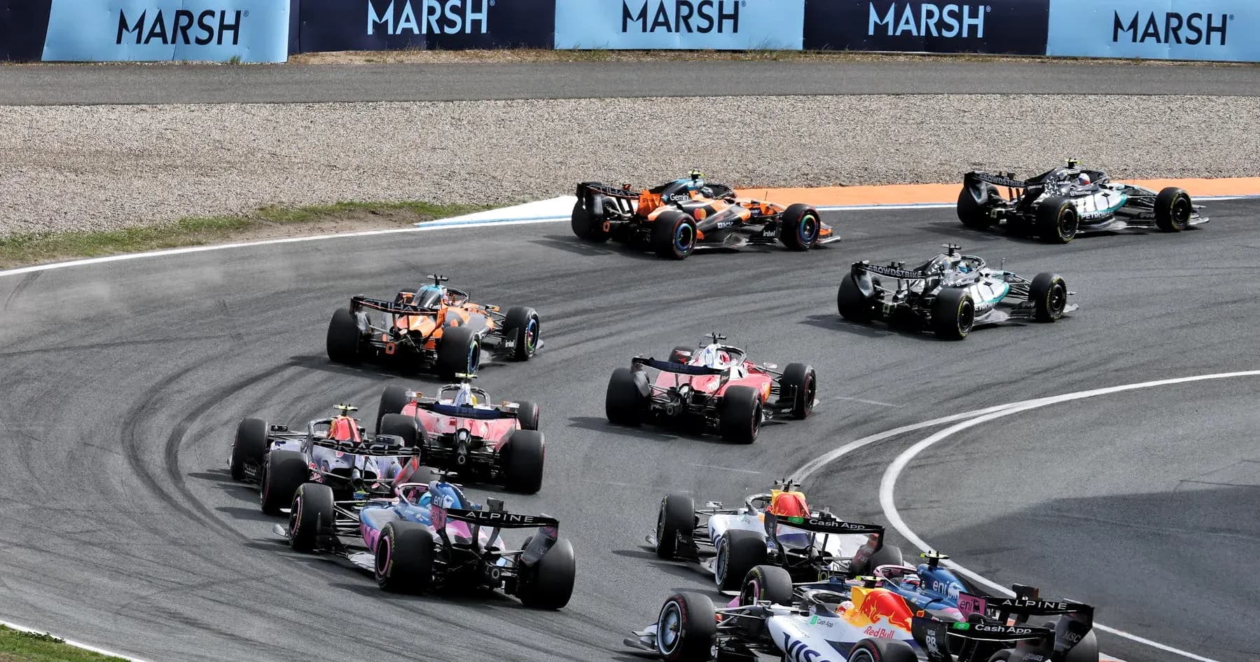 Formula 1 cars racing around a tight curve Formula 1 cars racing around a tight curve
