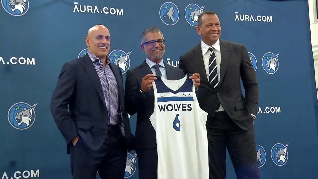Three men presenting a Minnesota Wolves jersey Three men presenting a Minnesota Wolves jersey