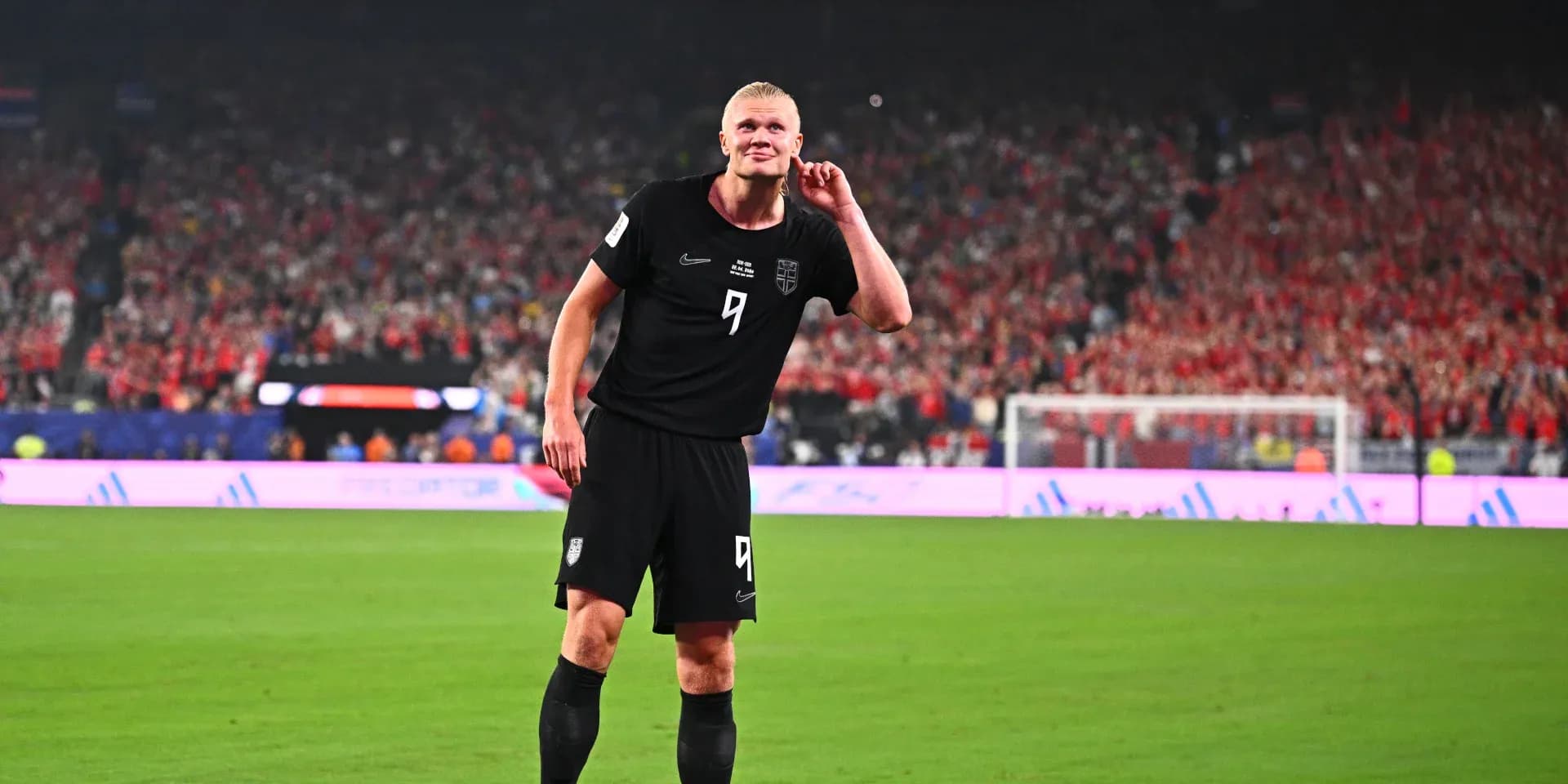 Futbolchi maydonda qo'lini quloq tomon qo'ygan Futbolchi maydonda qo'lini quloq tomon qo'ygan