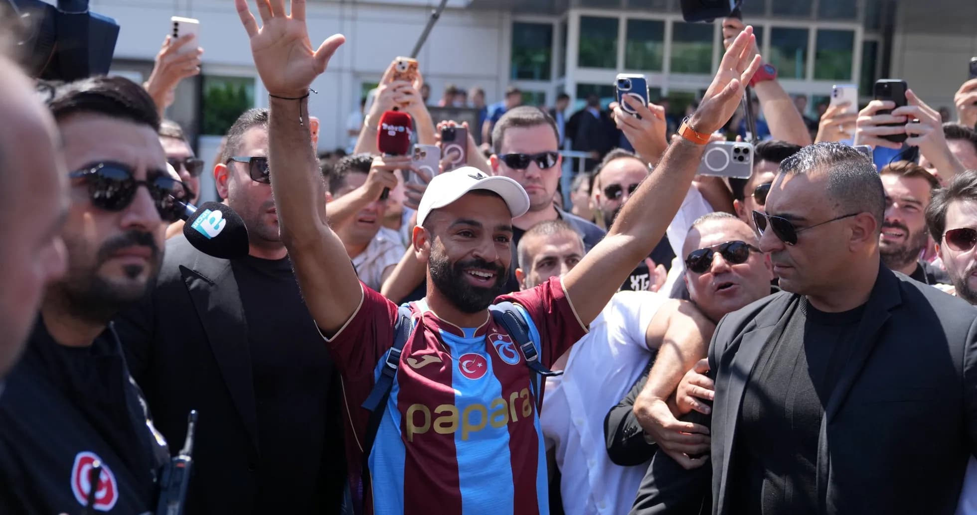 Futbolchi muxlislar orasida qo'l ko'tarib turibdi Futbolchi muxlislar orasida qo'l ko'tarib turibdi