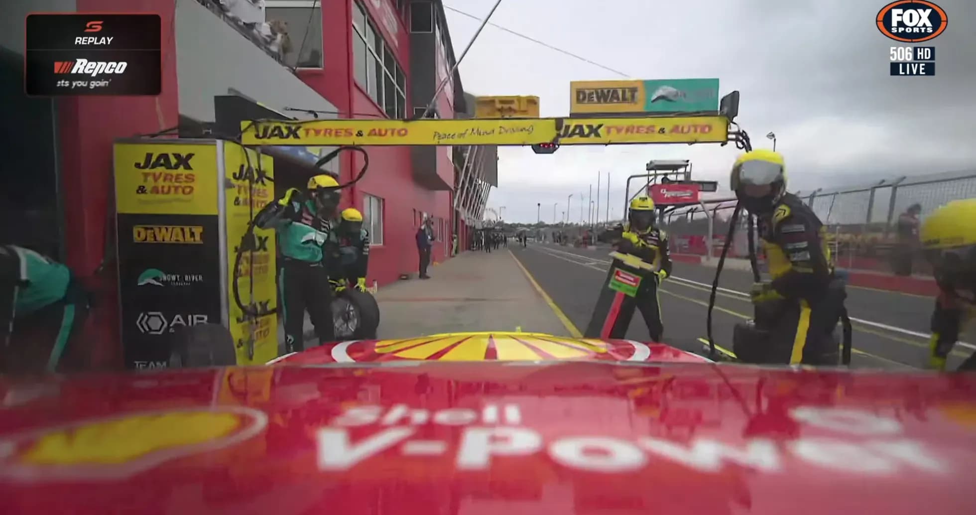 Pit crew servicing car during race pit stop Pit crew servicing car during race pit stop