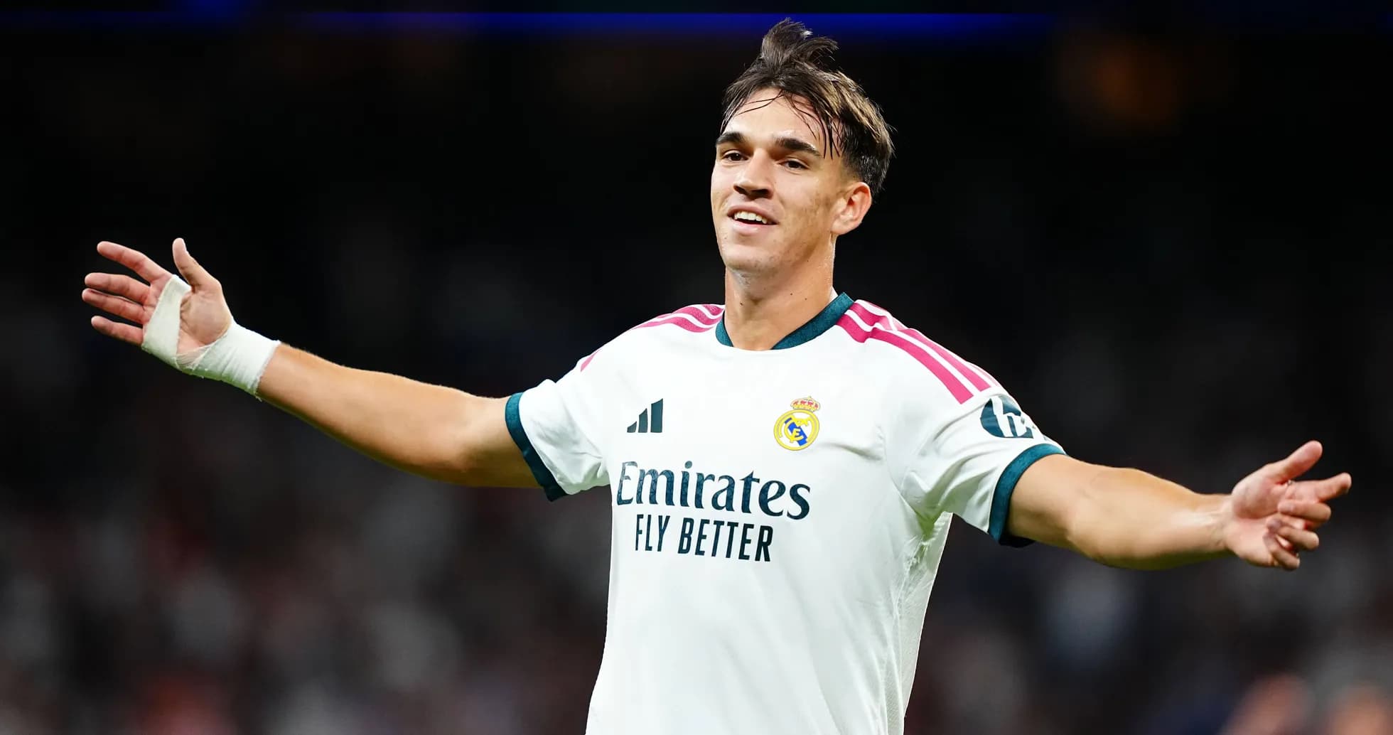 Futbolchi Real Madrid formasida maydonda qo'llarini ochmoqda Futbolchi Real Madrid formasida maydonda qo'llarini ochmoqda