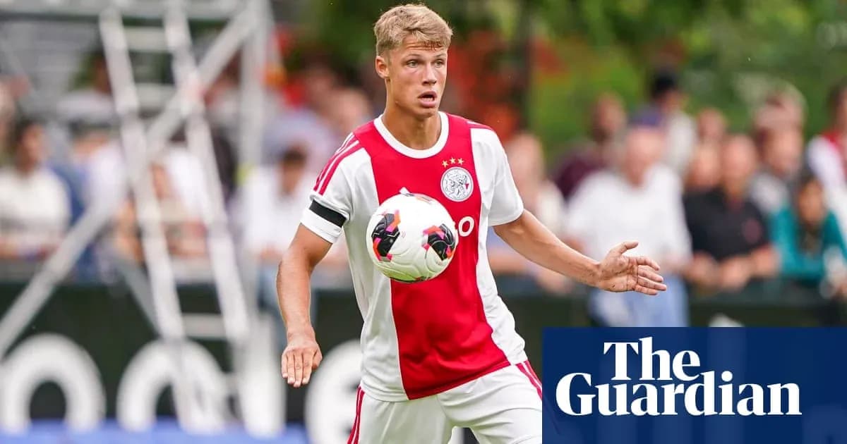 Futbolchi Ajax formasida to'pni ushlayotgan Futbolchi Ajax formasida to'pni ushlayotgan