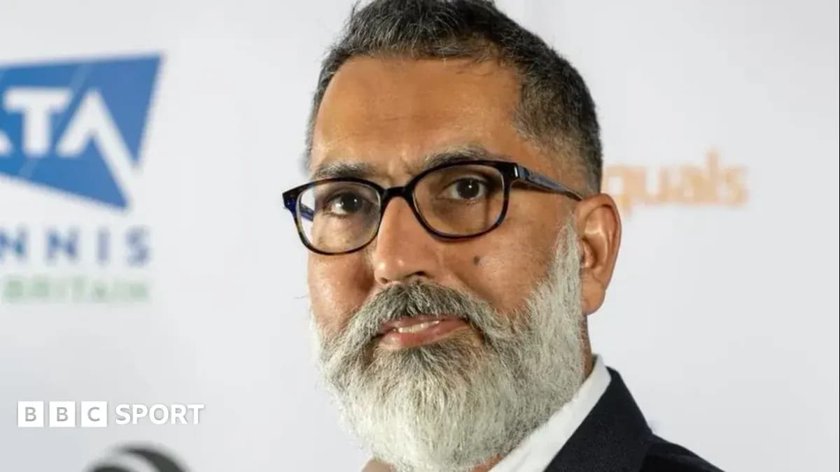 Man with glasses and beard in front of logo Man with glasses and beard in front of logo