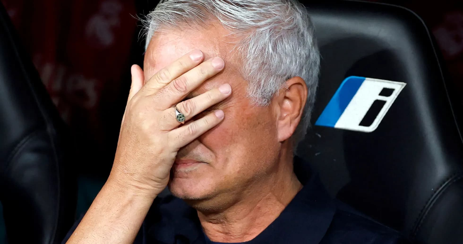 Coach covering face with hand on bench Coach covering face with hand on bench