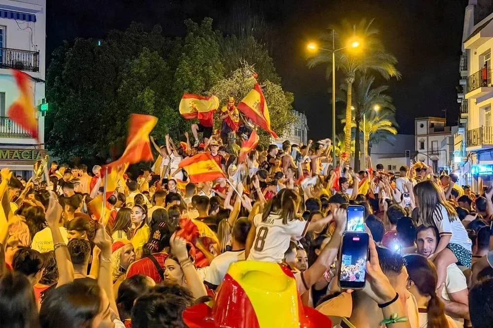 Odamlar Ispaniya bayroqlarini ko'tarib, tantana qilishmoqda Odamlar Ispaniya bayroqlarini ko'tarib, tantana qilishmoqda