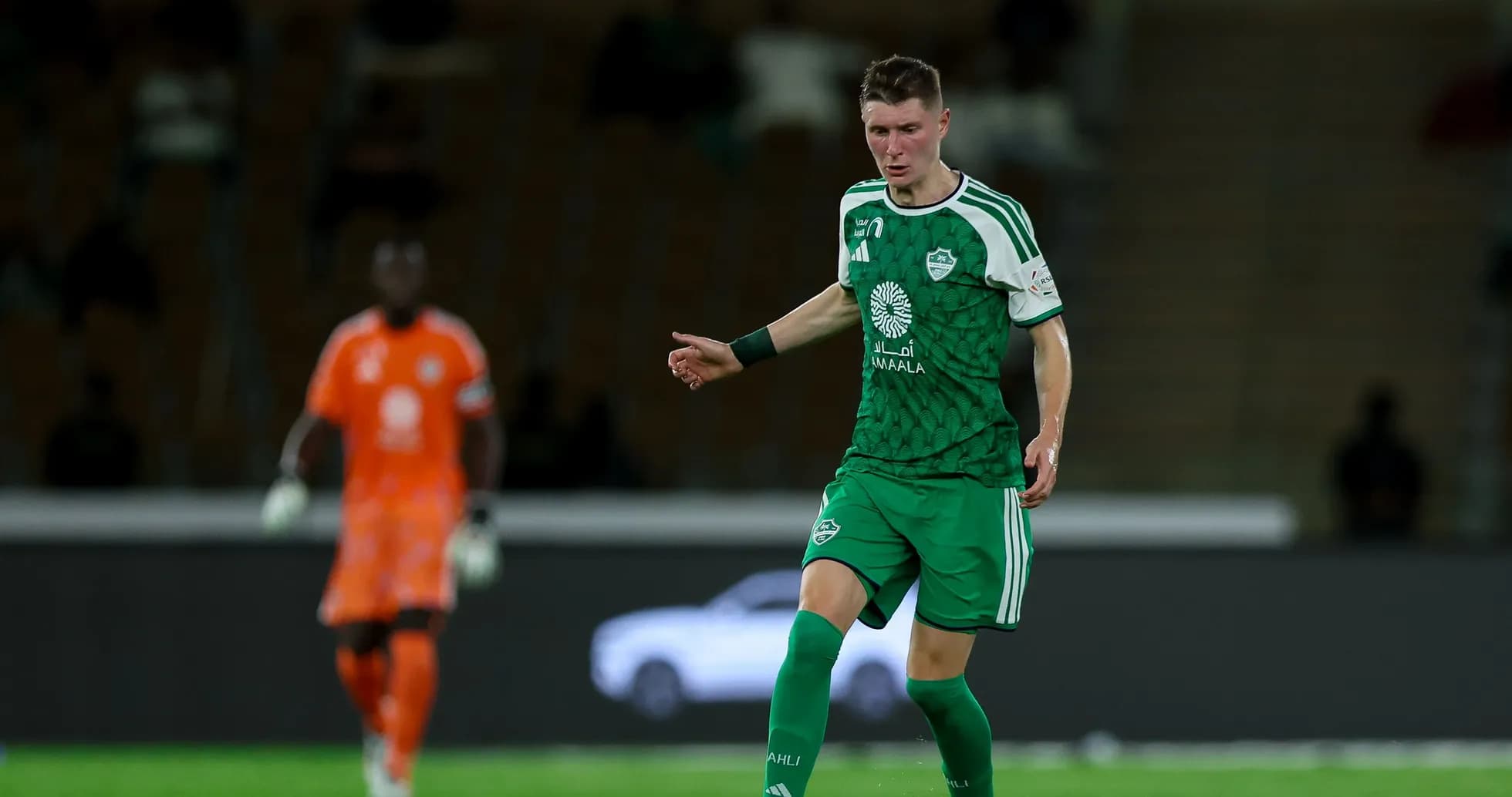 Futbolchi yashil forma kiygan, to'p bilan harakatda Futbolchi yashil forma kiygan, to'p bilan harakatda