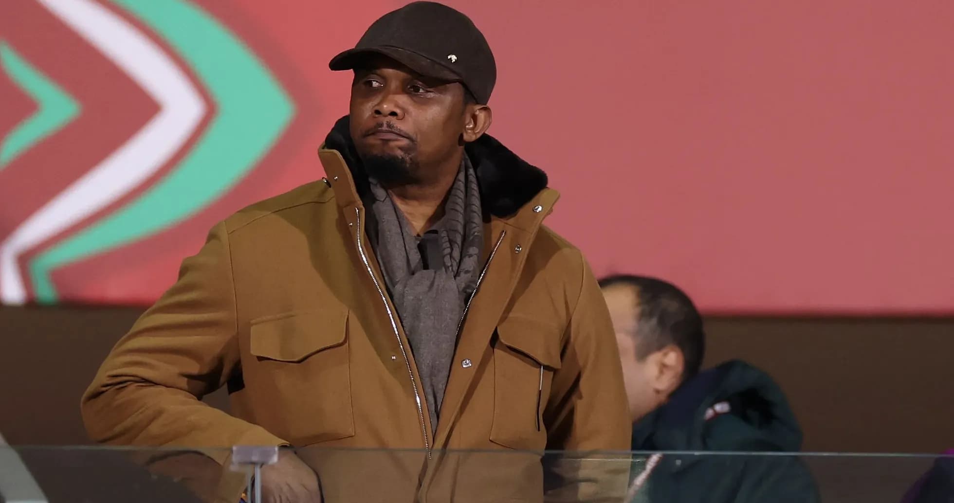 Man in brown coat observing from a stand Man in brown coat observing from a stand