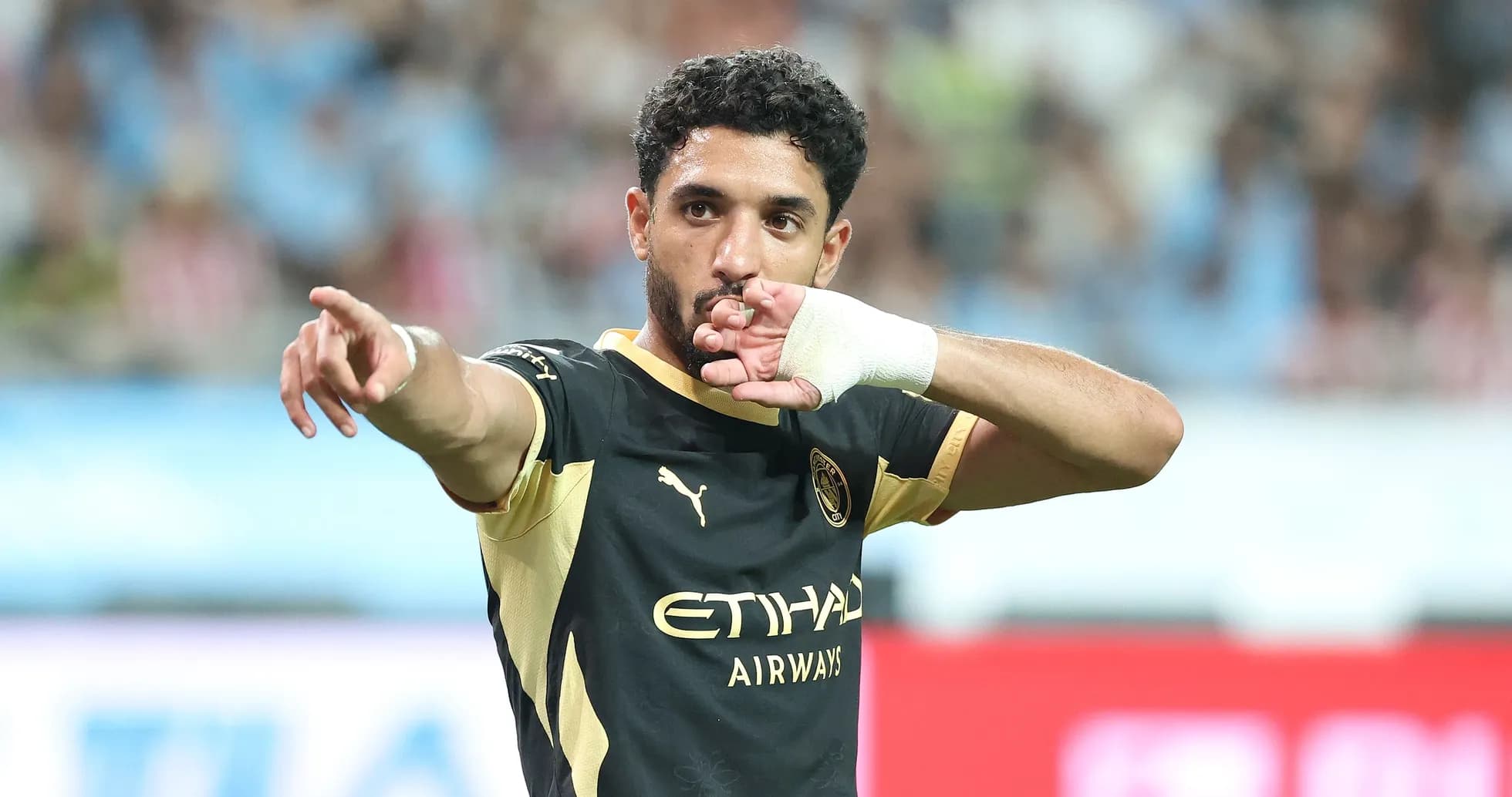 Futbolchi maydonda qo'lini ko'tarib ko'rsatmoqda Futbolchi maydonda qo'lini ko'tarib ko'rsatmoqda