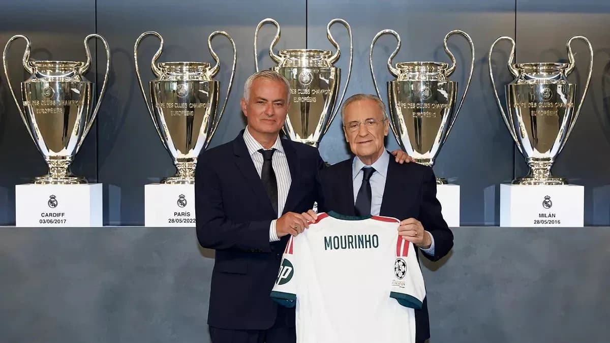 Mourinho holding jersey with trophies in background Mourinho holding jersey with trophies in background