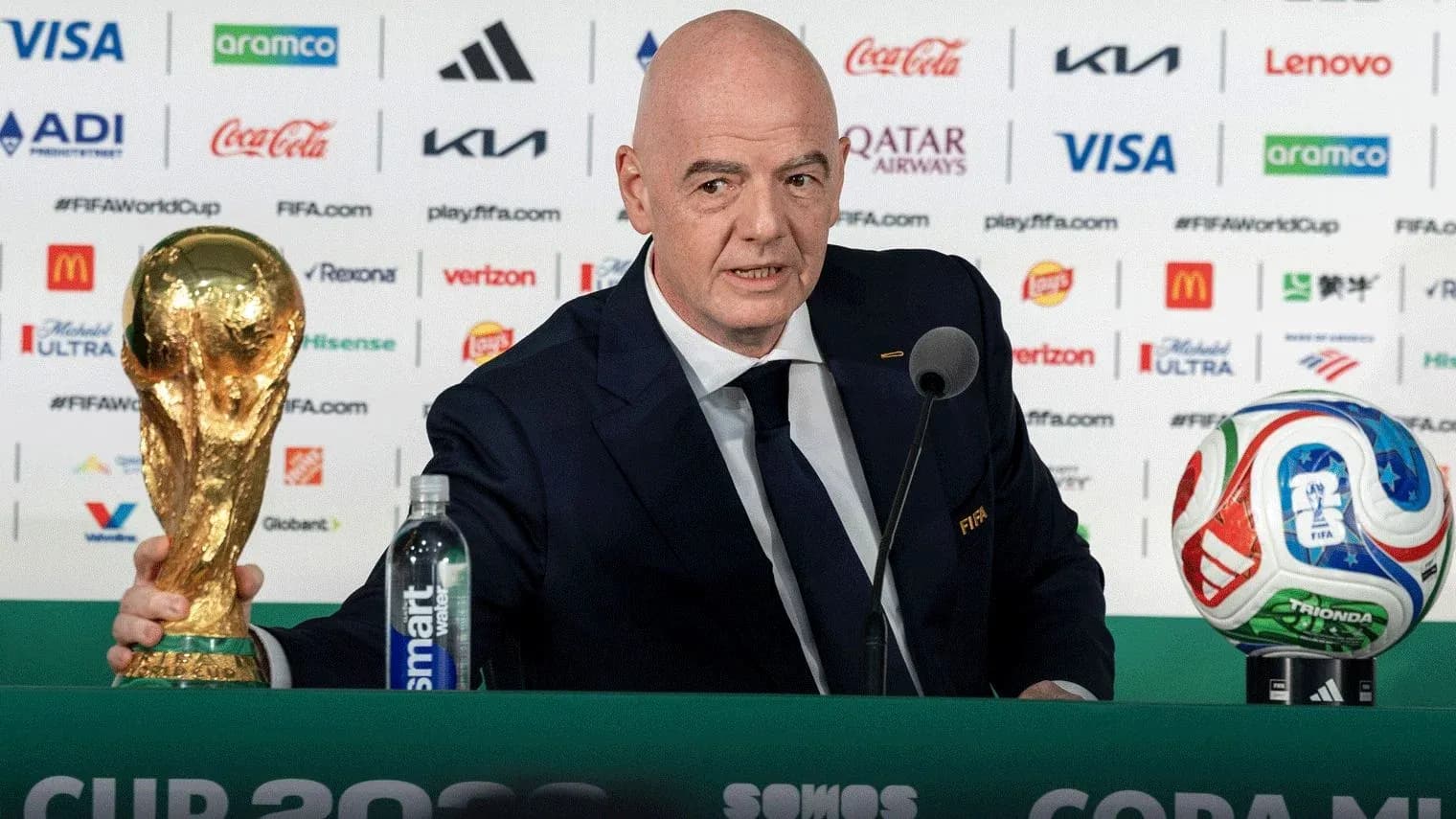 FIFA president presenting World Cup trophy at podium FIFA president presenting World Cup trophy at podium