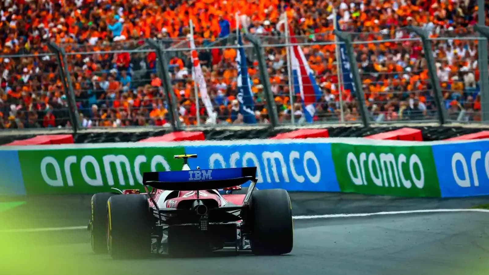 Formula 1 car racing past cheering crowd Formula 1 car racing past cheering crowd