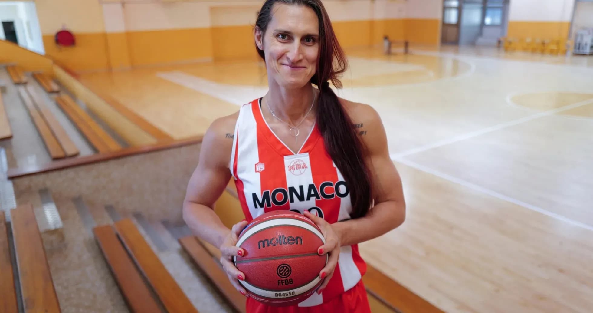 Basketball player holding ball in gym Basketball player holding ball in gym