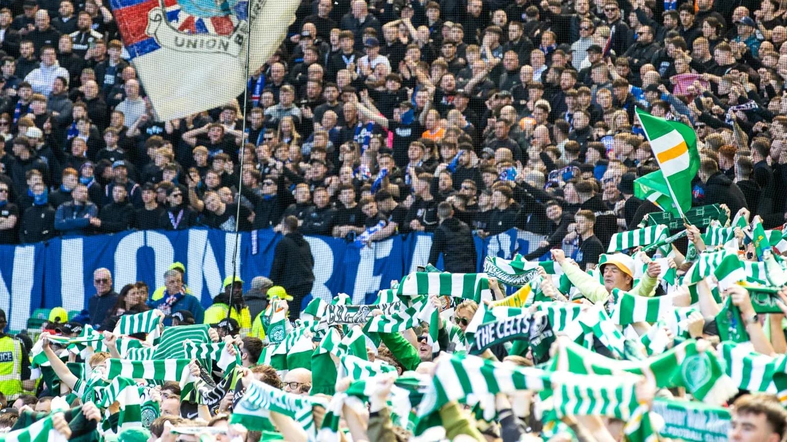 Celtic fans waving scarves in stadium stands Celtic fans waving scarves in stadium stands