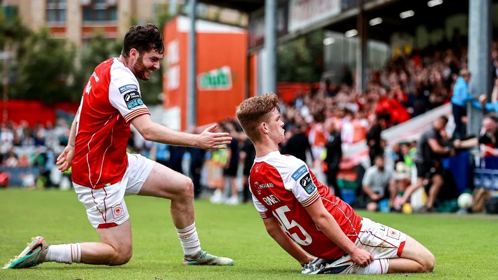 Two players celebrating a goal on the pitch Two players celebrating a goal on the pitch