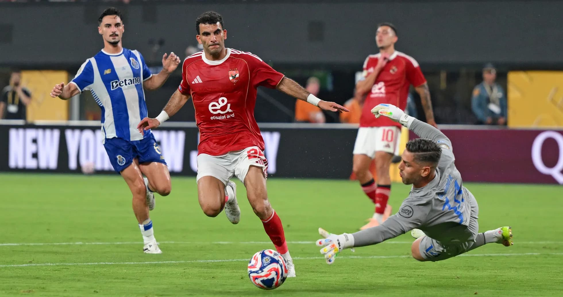 Player attempting to score while goalkeeper dives Player attempting to score while goalkeeper dives