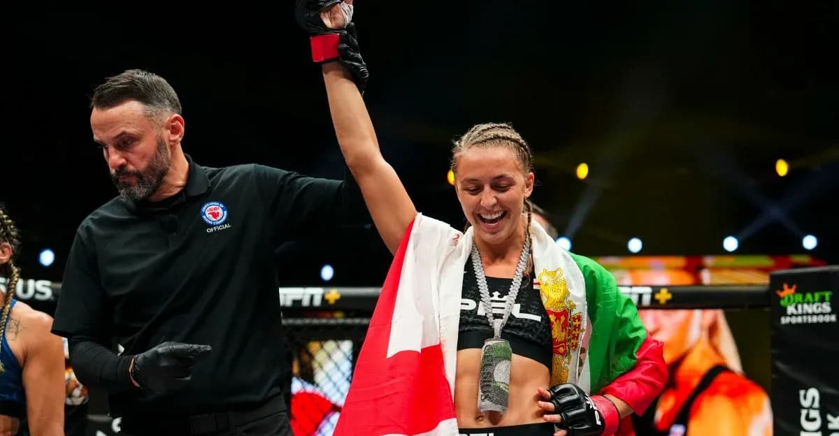 Fighter celebrating victory with referee in octagon Fighter celebrating victory with referee in octagon