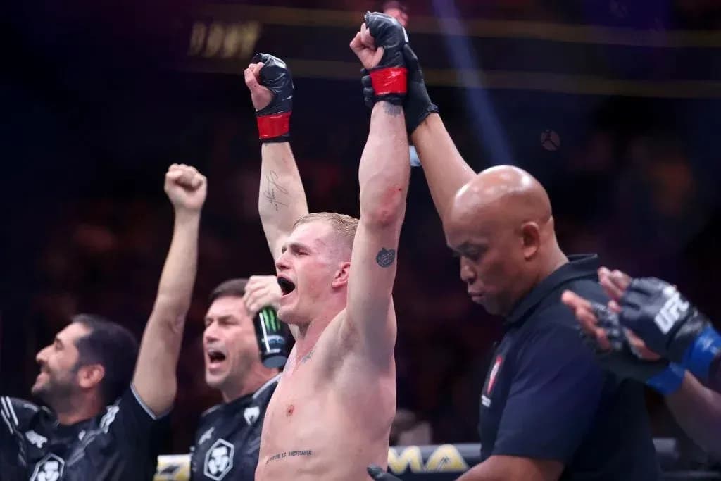 Fighter celebrating victory with raised hands in octagon Fighter celebrating victory with raised hands in octagon